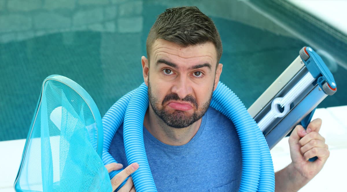 Guy with a bunch of Pool tools to clean the murk green water in the background